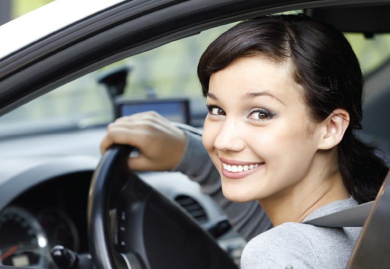 Smiling young female in driver's seat of a car